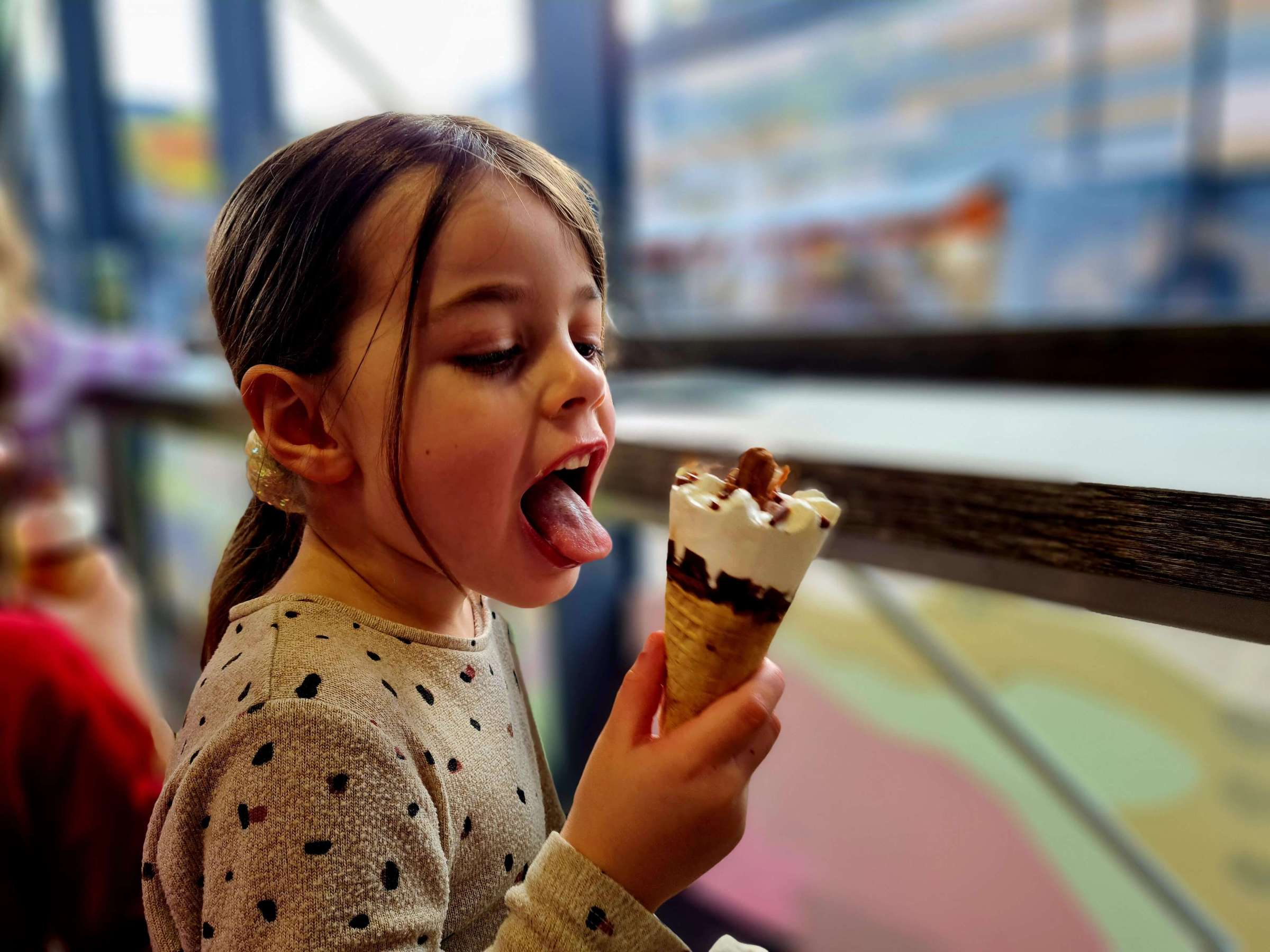 a close up of a little girl eating an ice cream