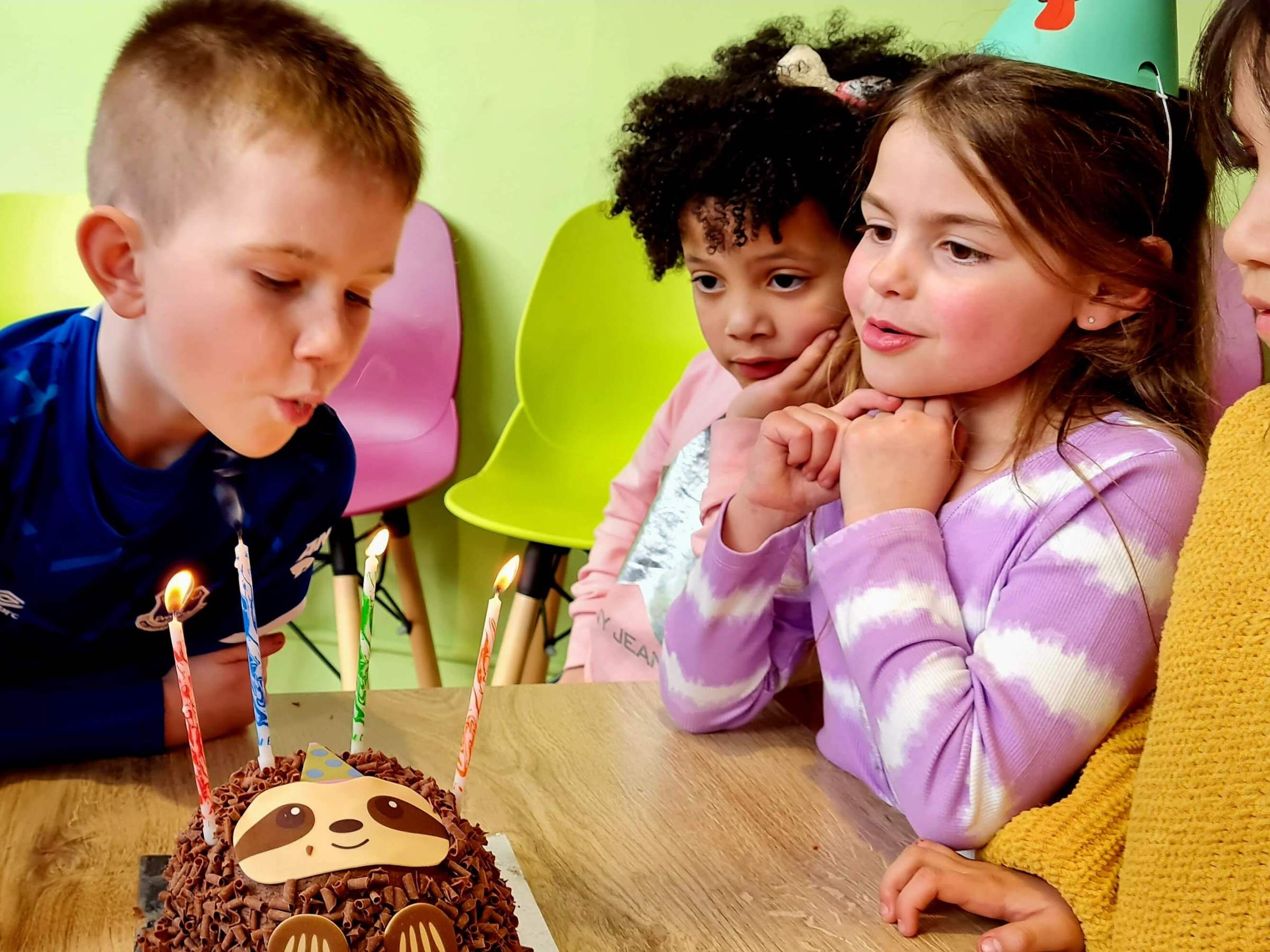 a little boy blowing out the candles of a birthday cake