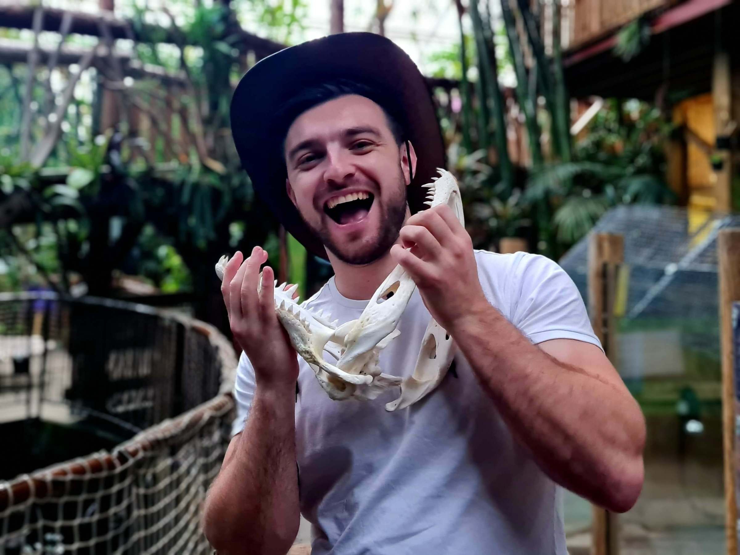 a man holding a crocodile skeleton under his jaw