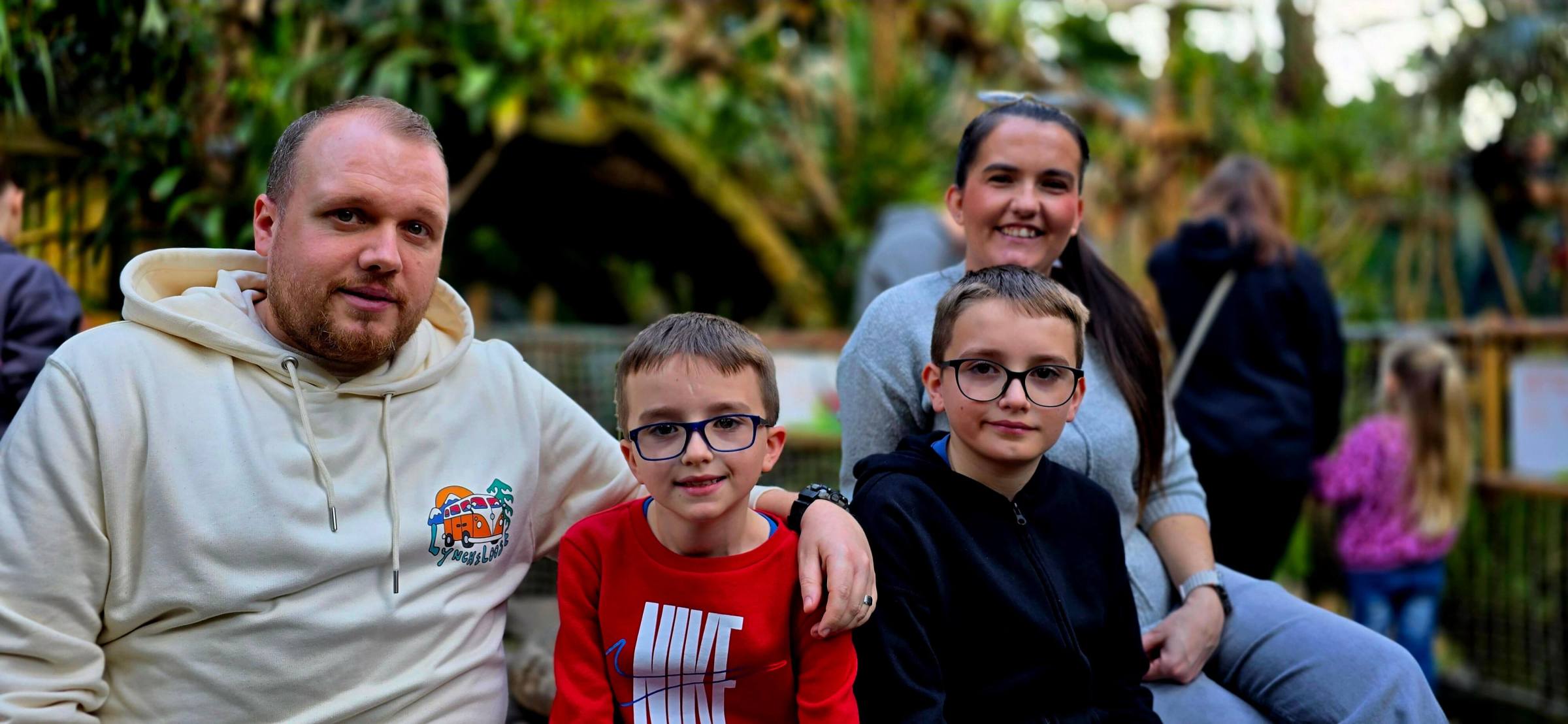 a family with 2 children sitting in a jungle setting