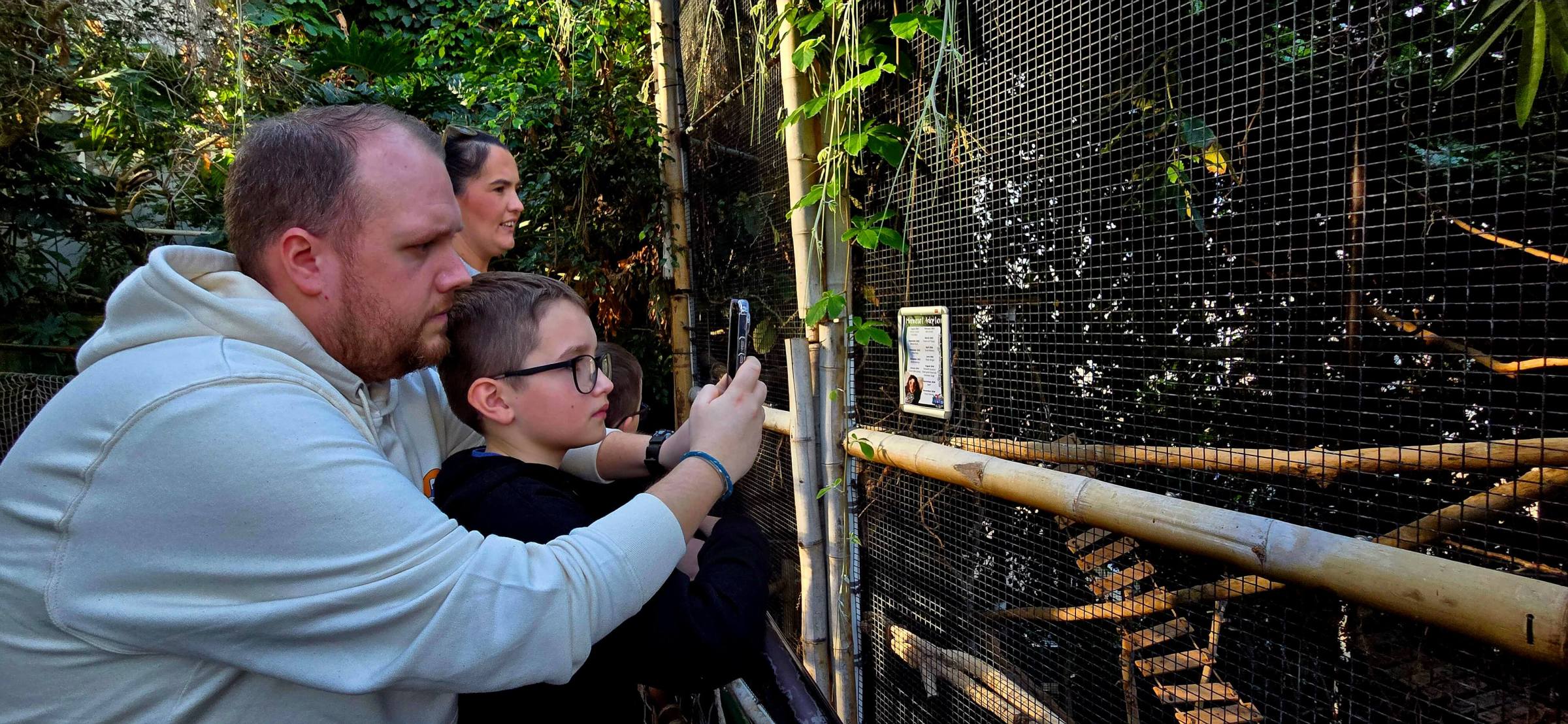 a person holding a baseball bat in front of a fence