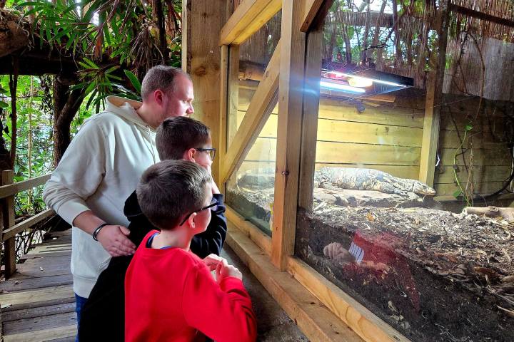 a man sitting in front of a fence