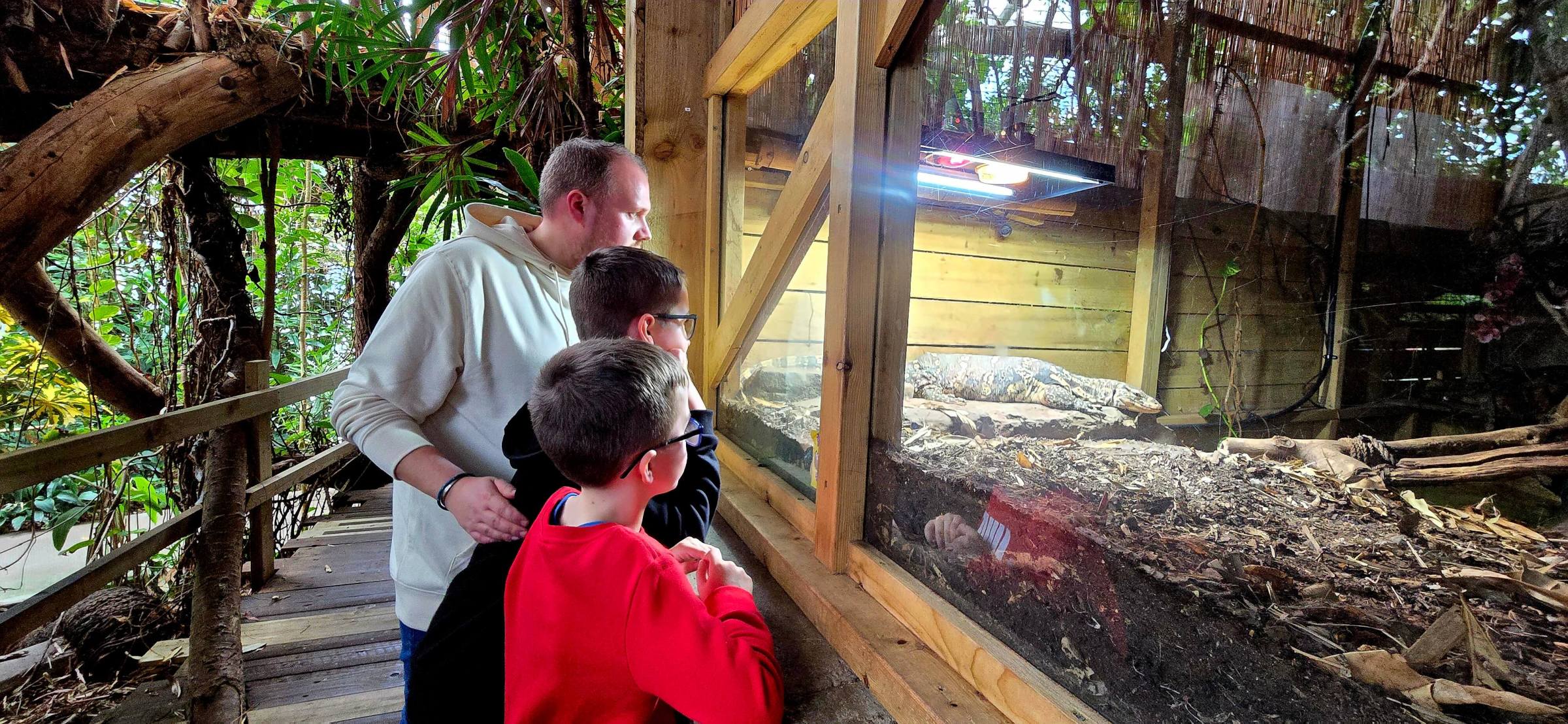 a man sitting in front of a fence
