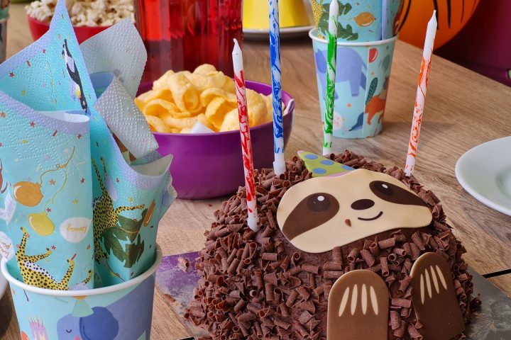 a person sitting at a table with a birthday cake