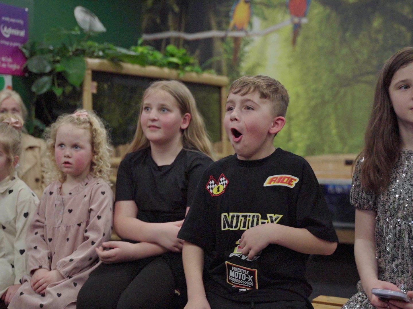a group of children in a line looking surprised