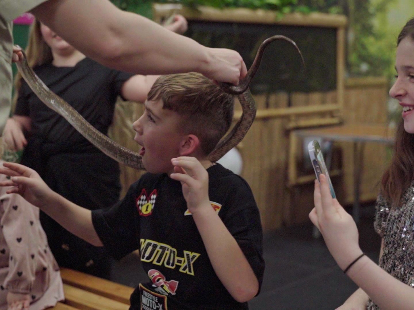 a young boy with a snake around his neck
