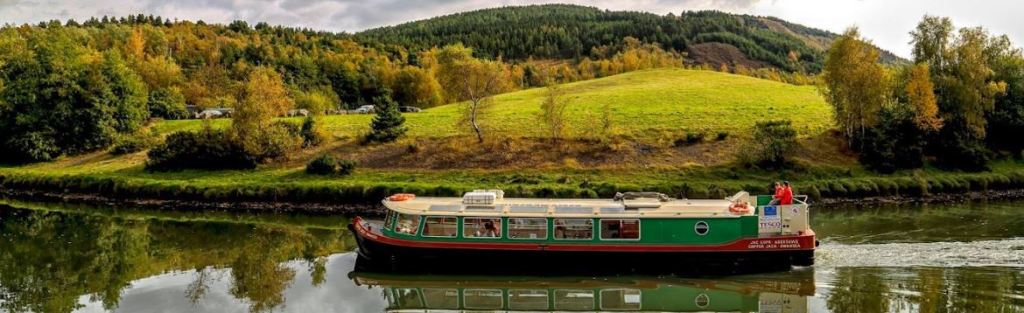 a small boat in a river next to a body of water