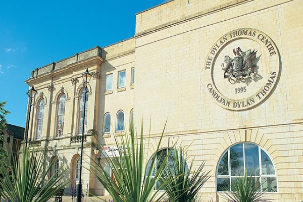 a clock on the side of the Dylan Thomas Centre building