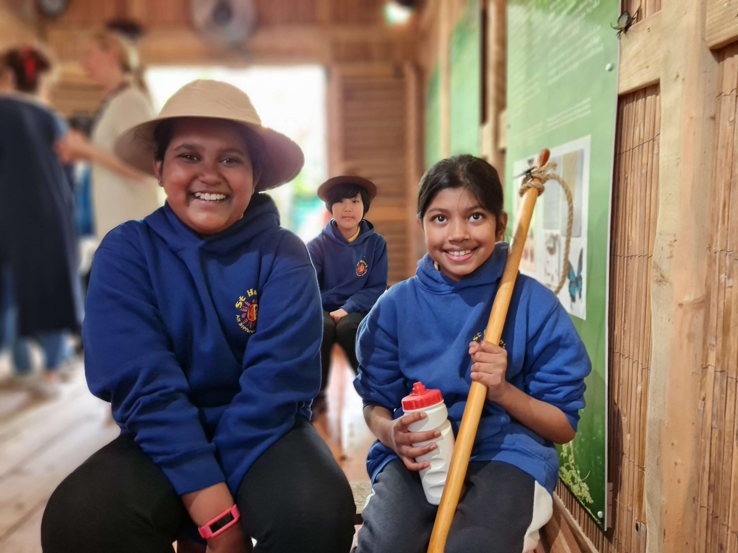 two children sitting, holding a boat paddle