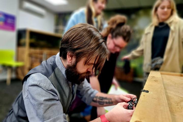 a man crouching down to open a lock