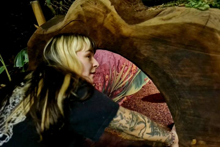 A woman crouched down by a cave enterance