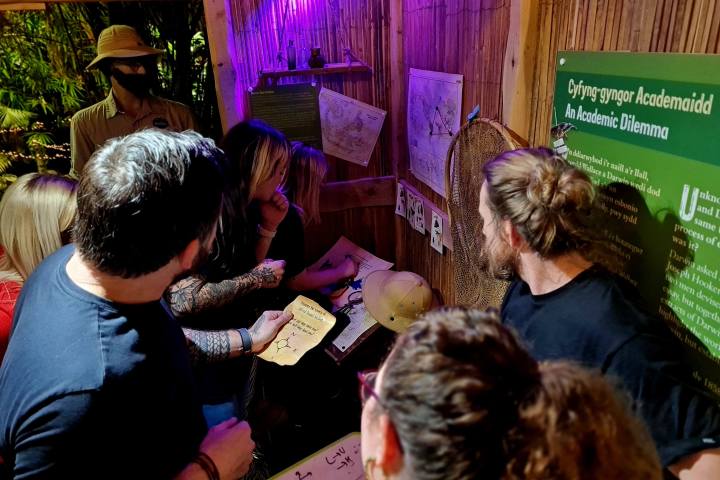 a group of people in a hut looking at information on the wall