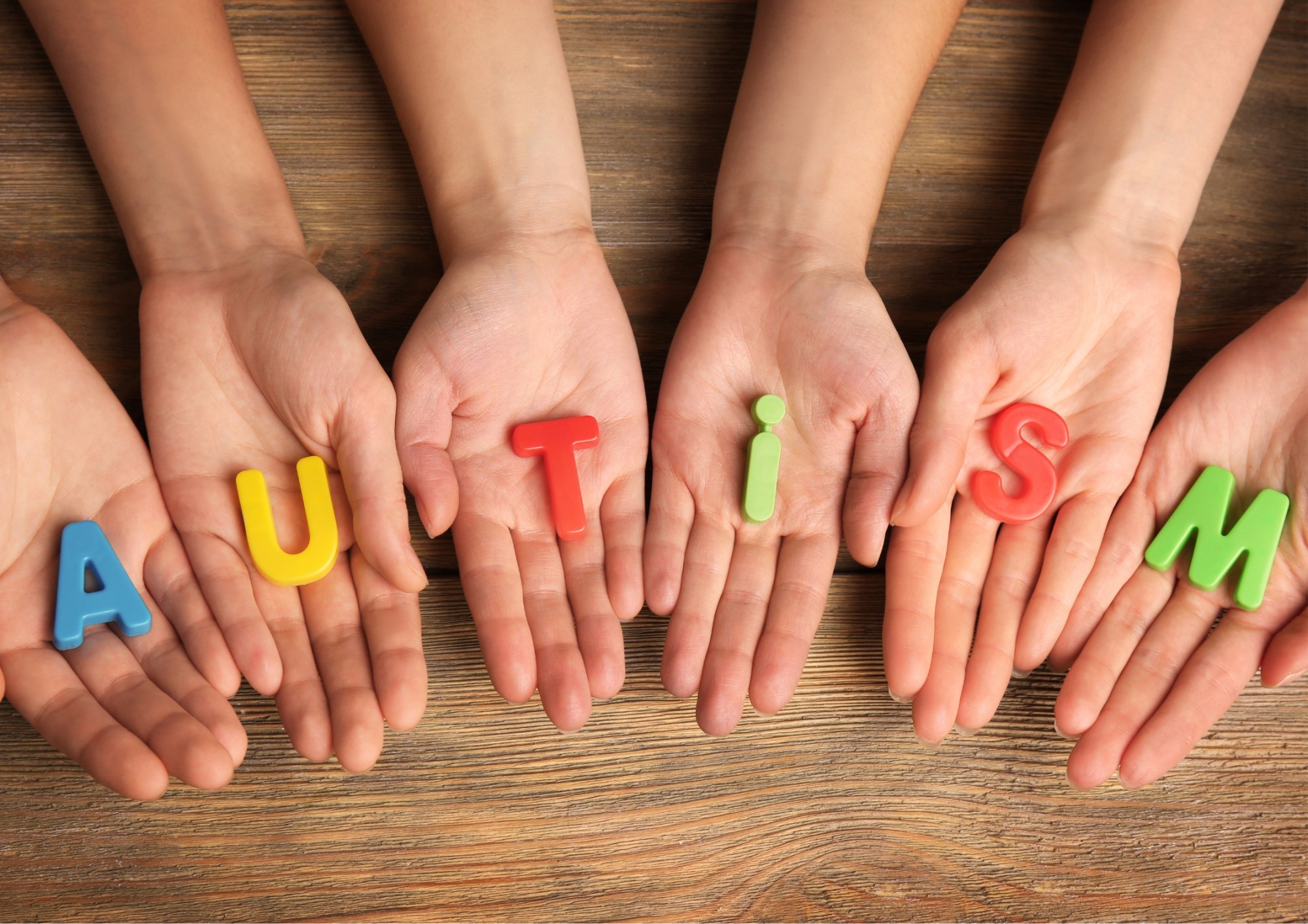 Untitled design Kids hands holding letters that spell the world Autism
