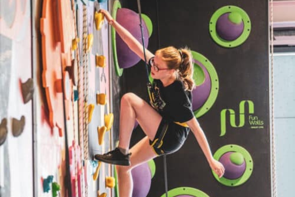 A girl climbing a climbing wall