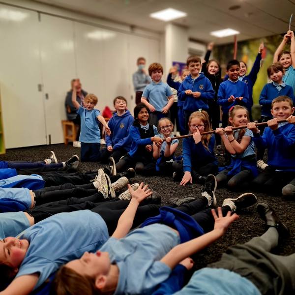 a group of school children demonstrating the different layers o the rainforest