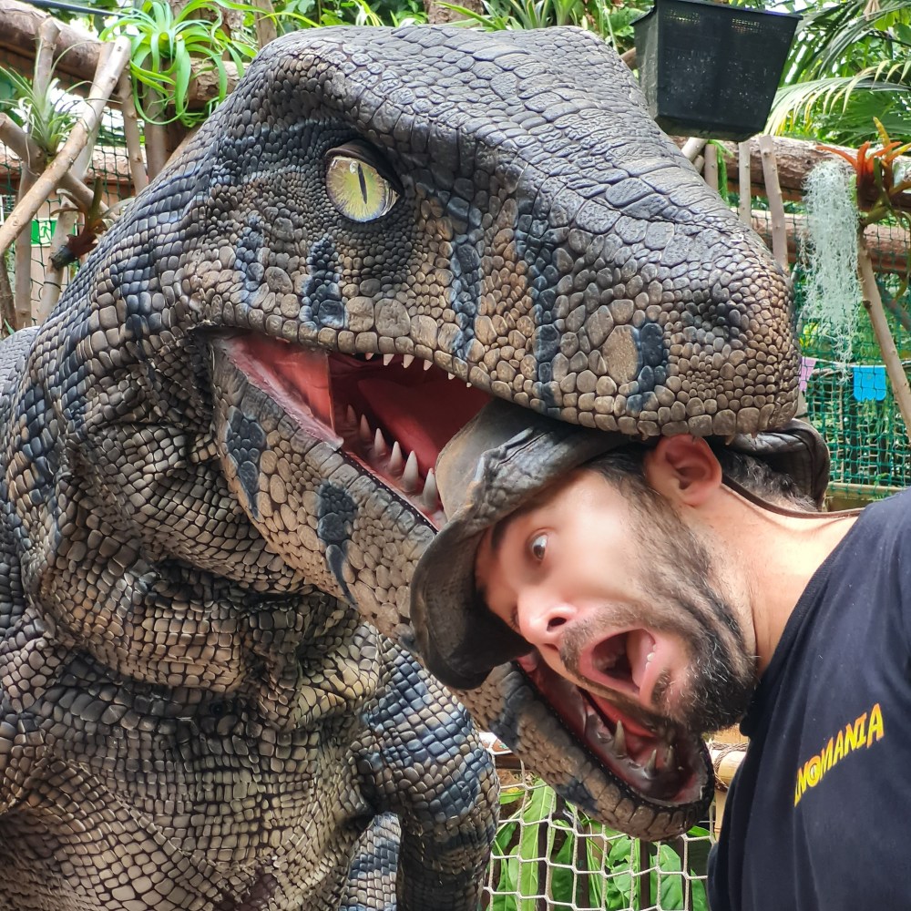 a man holding his head in a dinosaurs mouth